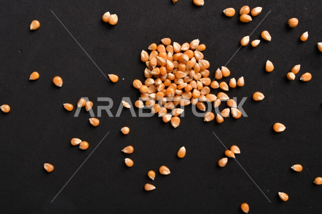 صورة لحبوب الذرة على خلفية سوداء ، حبوب الذرة المجففة الذهبية ، حبيبات الذرة الخاصة بالفشار