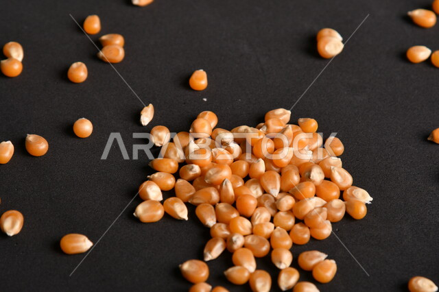 صورة لحبوب الذرة على خلفية سوداء ، حبوب الذرة المجففة الذهبية ، حبيبات الذرة الخاصة بالفشار