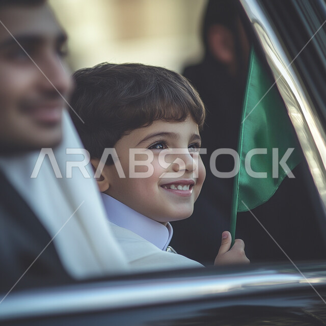 أعياد ومناسبات وطنية شعبية, الاحتفال باليوم الوطني السعودي 23 سبتمبر, مفهوم الاعتزاز و الفخر و الانتماء للوطن, صورة مقربة لولد عربي خليجي سعودي يرتدي الثوب التقليدي يحمل بيده راية خضراء و ينظر بإيماءات السعادة والسرور