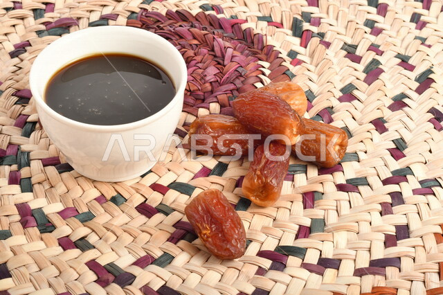 صورة لمجموعة من حبات التمر بجانب وعاء دبس التمر الصحي ، وعاء من القش ، عسل التمر ، غذاء صحي ولذيذ