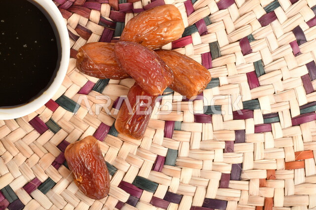 صورة لمجموعة من حبات التمر بجانب وعاء دبس التمر الصحي ، وعاء من القش ، عسل التمر ، غذاء صحي ولذيذ
