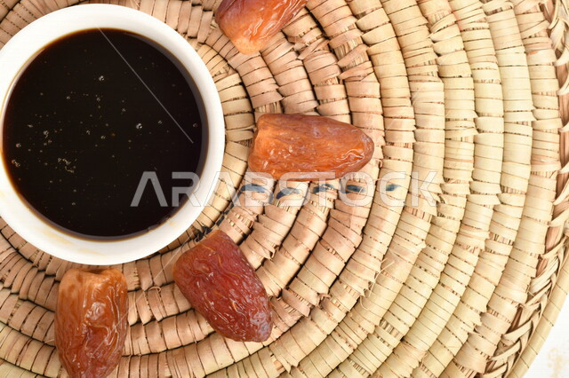 صورة لمجموعة من حبات التمر بجانب وعاء دبس التمر الصحي ، وعاء من القش ، عسل التمر ، غذاء صحي ولذيذ