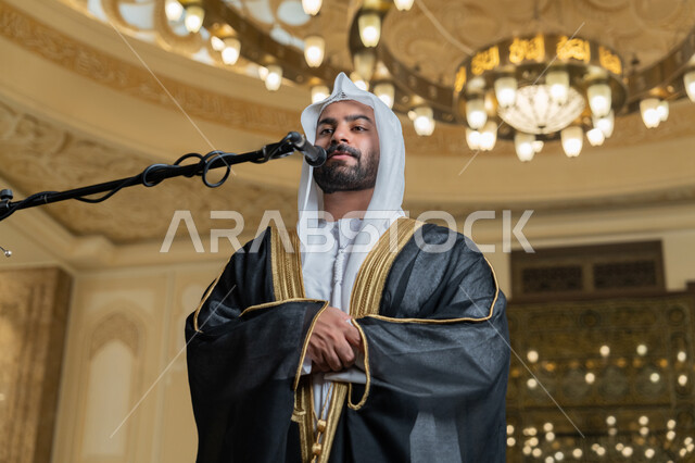 أداء فرائض الدين الإسلامي, إقامة الصلاة على وقتها، إمامة المسلمين في المسجد, الشعور بالخشوع والطمأنينة, الركن الثاني من أركان الإسلام, صورة مقربة لإمام عربي خليجي إماراتي يرتدي البشت والكندورة والغترة البيضاء يقوم بأداء فريضة الصلاة