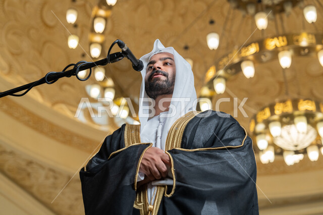 إقامة الصلاة على وقتها، إمامة المسلمين في المسجد, الشعور بالخشوع والطمأنينة, الركن الثاني من أركان الإسلام, أداء فرائض الدين الإسلامي, صورة مقربة لإمام عربي خليجي إماراتي يرتدي البشت والكندورة والغترة البيضاء يقوم بأداء فريضة الصلاة