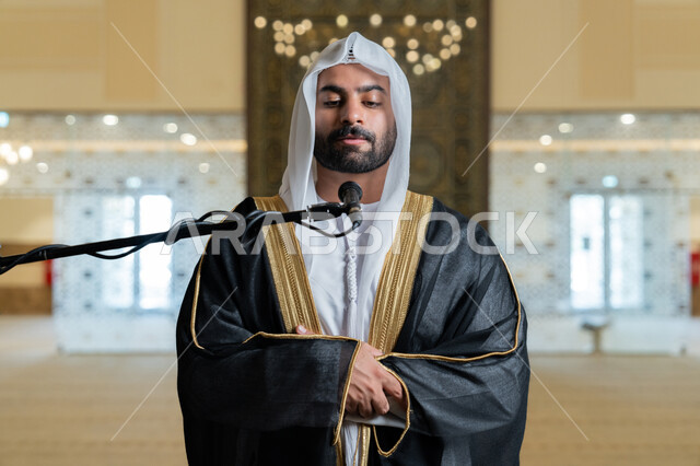 أداء فرائض الدين الإسلامي, إقامة الصلاة على وقتها، إمامة المسلمين في المسجد, الشعور بالخشوع والطمأنينة, الركن الثاني من أركان الإسلام, صورة مقربة لإمام عربي خليجي إماراتي يرتدي البشت والكندورة والغترة البيضاء يقوم بأداء فريضة الصلاة