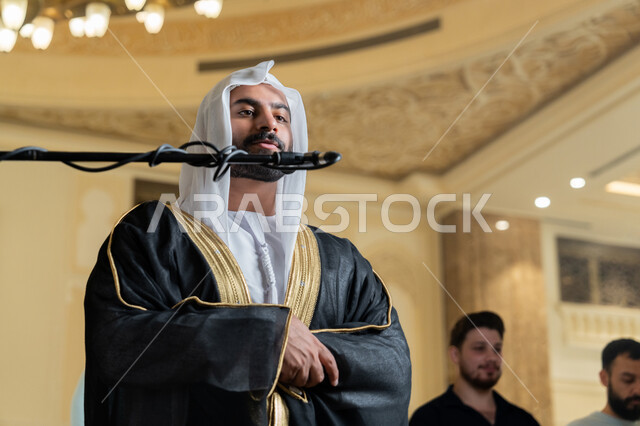 إقامة الصلاة على وقتها، إمامة المسلمين في المسجد, الشعور بالخشوع والطمأنينة, الركن الثاني من أركان الإسلام, أداء فرائض الدين الإسلامي, صورة مقربة لإمام عربي خليجي إماراتي يرتدي البشت والكندورة والغترة البيضاء يقوم بأداء فريضة الصلاة