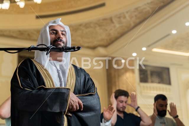 إمامة المسلمين في المسجد, الشعور بالخشوع والطمأنينة, الركن الثاني من أركان الإسلام, أداء فرائض الدين الإسلامي, إقامة الصلاة على وقتها، صورة مقربة لإمام عربي خليجي إماراتي يرتدي البشت والكندورة والغترة البيضاء يقوم بأداء فريضة الصلاة