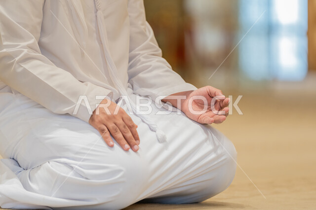 أذكار بعد الصلاة، الاستغفار والدعاء وذكر الله, مفهوم التعبد في بيوت الرحمن, أداء الفرائض الدينية الإسلامية, العبادة والتقرب الى الله, صورة مقربة لرجل عربي خليجي إماراتي يرتدي الكندورة يجلس في إحدى المساجد الإماراتية ويقوم بالتسبيح والتهليل