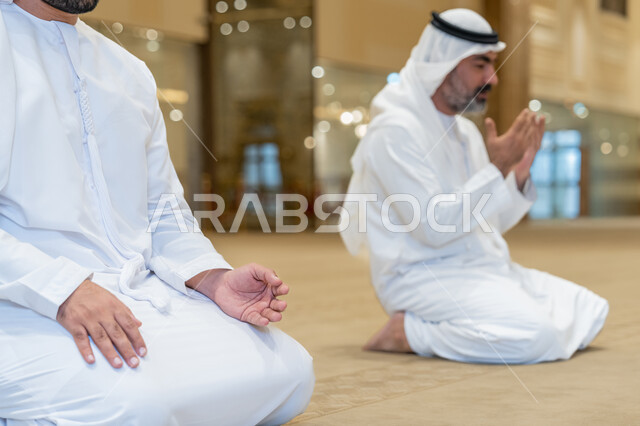 الجلوس للدعاء والاستغفار في احد المساجد بالامارات العربية المتحدة, رجلان عربيان اماراتيان خليجيان يرتديان الكندورة والغترة البيضاء يؤدي فريضة الصلاة، الخشوع والتضرع للرحمن، التقرب الى الله بأداء العبادات