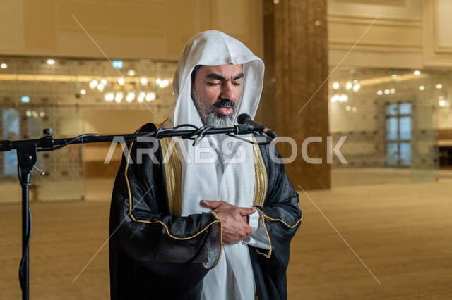 أداء فرائض الدين الإسلامي, إقامة الصلاة على وقتها، إمامة المسلمين في المسجد, الشعور بالخشوع والطمأنينة, الركن الثاني من أركان الإسلام, صورة مقربة لإمام عربي خليجي إماراتي يرتدي البشت والكندورة والغترة البيضاء يقوم بأداء فريضة الصلاة
