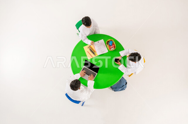 تعزيز المواهب الابداعية عند الطلاب، أنشطة ترفيهية مسلية، مفهوم الاهتمام بالهوايات، تعلم مهارات التركيز والابتكار، بورتريه علوي عامودي لتلاميذ عرب خليجيين سعوديين يرتدون الزي التقليدي يقومون بالرسم والتلوين واستخدام الاجهزة التقنية الحديثة، خلفية بيضاء