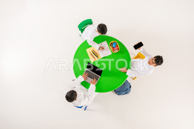 مفهوم الاهتمام بالهوايات، تعزيز المواهب الابداعية عند الطلاب، أنشطة ترفيهية مسلية، تعلم مهارات التركيز والابتكار، بورتريه علوي عامودي لتلاميذ عرب خليجيين سعوديين يرتدون الزي التقليدي يقومون بالرسم والتلوين واستخدام الاجهزة التقنية الحديثة، خلفية بيضاء