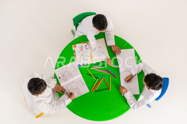 تعزيز المواهب الابداعية عند الطلاب، أنشطة ترفيهية مسلية، بورتريه علوي عامودي لتلاميذ عرب خليجيين سعوديين يرتدون الزي التقليدي يقومون بالرسم والتلوين، مفهوم الاهتمام بالهوايات، تعلم مهارات التركيز والابتكار، خلفية بيضاء
