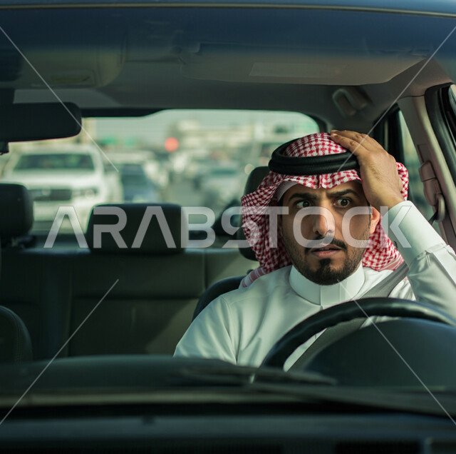 الازدحام المروري لحركة السيارات في شوارع وطرقات الرياض، صورة لشاب عربي سعودي خليجي يرتدي الزي التقليدي والشماغ يجلس داخل سيارته, تعابير الاحباط والتوتر بسبب الانتظار والتأخير عن موعد ما