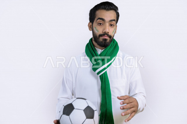 بورتريه لشاب عربي سعودي خليجي يحمل كرة القدم بيده , يضع وشاح نادي الفريق ، مشجع لفريق الأهلي وفريق السعودية ، إيماءات وجه ويدين مختلفة , أندية وتشجيع , خلفية بيضاء .