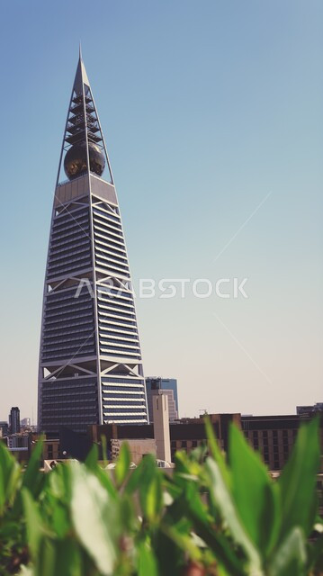 النمو والتطور العمراني في العاصمة، برج الفيصلية في مدينة الرياض في وقت النهار، الفن الهندسي المعماري للأبراج وناطحات السحاب في المملكة العربية السعودية، معالم ومباني مشهورة، الاهتمام بالتشجير و زراعة الاشجار الخضراء في المدن السياحية