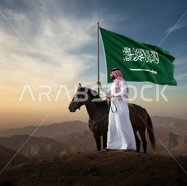 Celebrating Flag Day March 11, Remembering History and National Identity, Saudi National Day September 23, Saudi Arabian Gulf man standing with horses in the mountains wearing traditional dress and shemagh holding the national flag in his hand