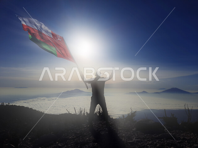 رفع علم الكويت عاليا، مناسبات وأعياد وطنية، الاحتفال بالعيد الوطني الكويتي 25 فبراير، صورة ظلية من الخلف لرجل يرفع الراية وقت غروب الشمس، إحياء ذكرى يوم العلم، حب الوطن والإنتماء اليه، الفخر والإعتزاز بالرموز والثقافة الكويتية