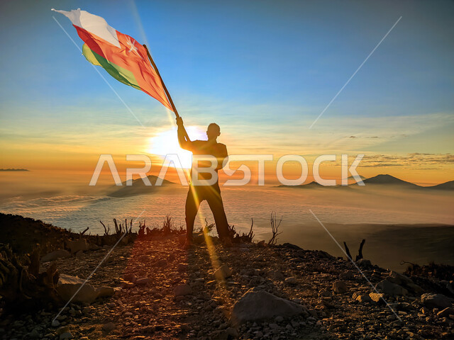 رفع علم الكويت عاليا، مناسبات وأعياد وطنية، الاحتفال بالعيد الوطني الكويتي 25 فبراير، صورة ظلية من الخلف لرجل يرفع الراية وقت غروب الشمس، إحياء ذكرى يوم العلم، حب الوطن والإنتماء اليه، الفخر والإعتزاز بالرموز والثقافة الكويتية