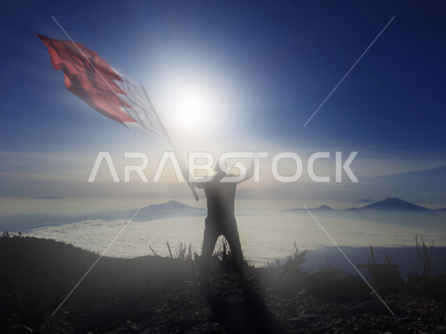 رفع علم الكويت عاليا، مناسبات وأعياد وطنية، الاحتفال بالعيد الوطني الكويتي 25 فبراير، صورة ظلية من الخلف لرجل يرفع الراية وقت غروب الشمس، إحياء ذكرى يوم العلم، حب الوطن والإنتماء اليه، الفخر والإعتزاز بالرموز والثقافة الكويتية