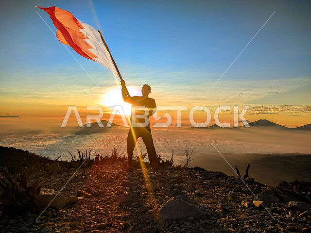 رفع علم الكويت عاليا، مناسبات وأعياد وطنية، الاحتفال بالعيد الوطني الكويتي 25 فبراير، صورة ظلية من الخلف لرجل يرفع الراية وقت غروب الشمس، إحياء ذكرى يوم العلم، حب الوطن والإنتماء اليه، الفخر والإعتزاز بالرموز والثقافة الكويتية