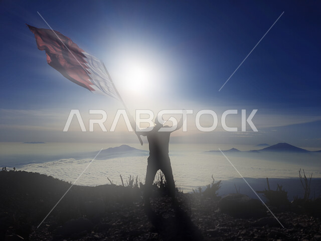 رفع علم الكويت عاليا، مناسبات وأعياد وطنية، الاحتفال بالعيد الوطني الكويتي 25 فبراير، صورة ظلية من الخلف لرجل يرفع الراية وقت غروب الشمس، إحياء ذكرى يوم العلم، حب الوطن والإنتماء اليه، الفخر والإعتزاز بالرموز والثقافة الكويتية