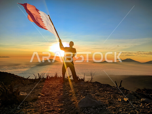 رفع علم الكويت عاليا، مناسبات وأعياد وطنية، الاحتفال بالعيد الوطني الكويتي 25 فبراير، صورة ظلية من الخلف لرجل يرفع الراية وقت غروب الشمس، إحياء ذكرى يوم العلم، حب الوطن والإنتماء اليه، الفخر والإعتزاز بالرموز والثقافة الكويتية