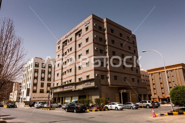 Old style architecture and historical mud buildings, historical civilization in Riyadh, authenticity and antiquity of Saudi heritage, popular tourist places and areas in the Kingdom of Saudi Arabia, a picture from below of Sama Wings in Al-Ulya, cars parking on paved roads and streets