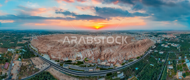 سلسلة جبال القارة في النهار، القمم والمرتفعات الجبلية في مدينة الاحساء، المعالم التاريخية الأثرية القديمة في المملكة العربية السعودية، منظر الغيوم والسحب البيضاء في السماء فوق التضاريس الطبيعية والتكوينات والتشكلات الصخرية