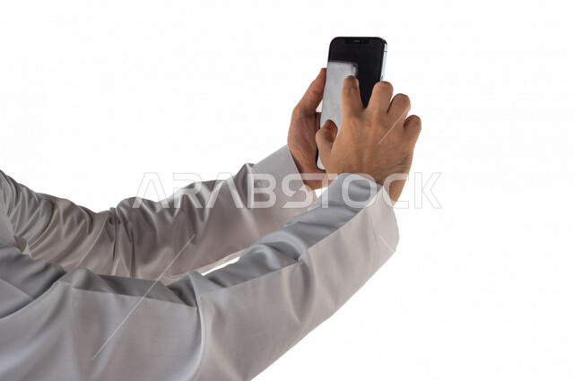 بورتريه لرجل خليجي سعودي يحمل بيده الهاتف المحمول ، اجراء اتصال فيديو ،تصوير سيلفي ،استخدام اجهزة تقنية حديثة ،  خلفية بيضاء