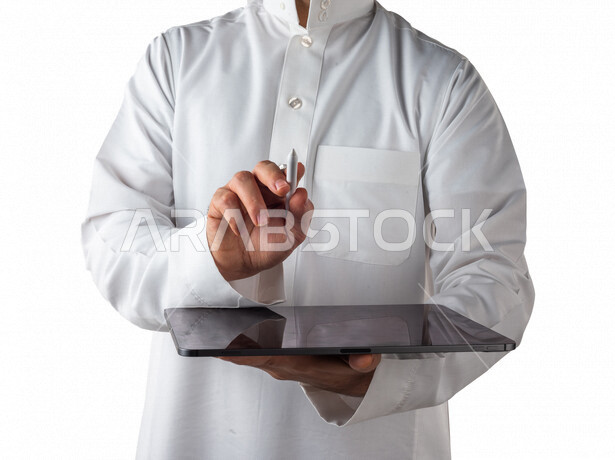بورتريه لرجل خليجي سعودي يحمل بيده جهاز التابلت ، يستخدم القلم الخاص للضغط على شاشة الجهاز التقني ،تنظيم وادارة الاعمال عبر الجهاز التقني ، خلفية بيضاء