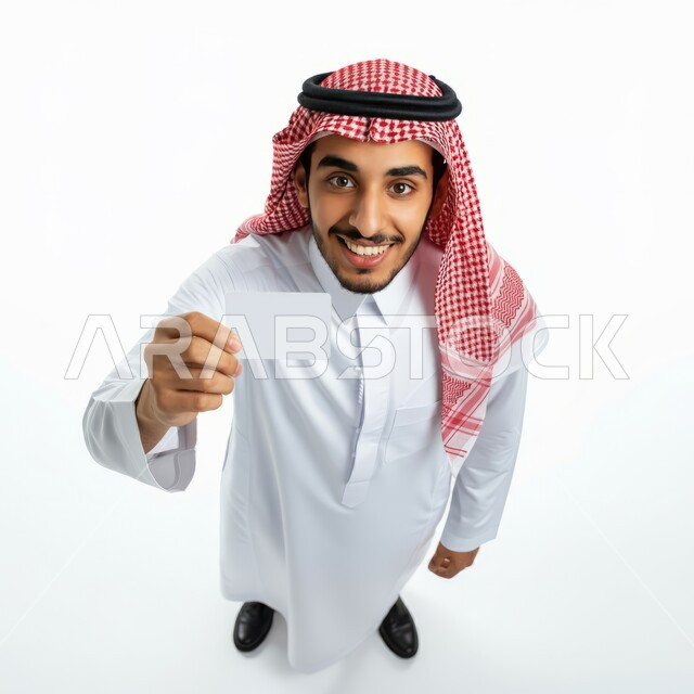 اعلانات و عروضات تسويقية, النظر الى الكاميرا بايماءات السرور السعادة، بورتريه من الاعلى لرجل عربي خليجي سعودي يرتدي الشماغ والثوب التقليدي يحمل بيده لوحة بيضاء مستطيلة، موك اب مستطيل أبيض، لوح اعلاني فارغ، صورة الجسم بالطول الكامل، خلفية بيضاء