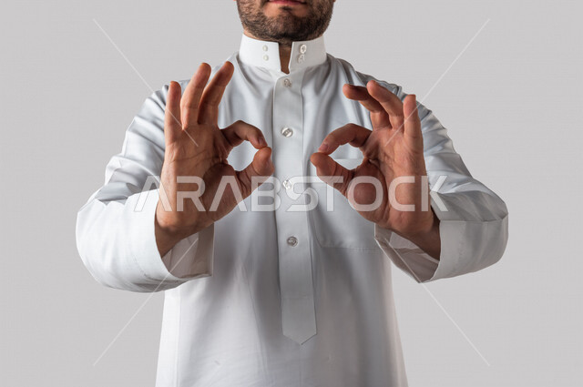 Hand portrait of a Saudi Gulf man making different hand gestures, a gesture indicating quality, workmanship, excellence and distinction, white background