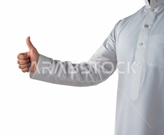 بورتريه لرجل خليجي سعودي يرتدي الزي الخليجي التقليدي يقوم بايماءات يد مختلفة ، يرفع اصبع الابهام لاعلى لاعجابه بشيء ما ، خلفية بيضاء