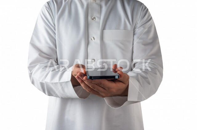 بورتريه لرجل خليجي سعودي يحمل بيده الهاتف المحمول ، استخدام اجهزة تقنية حديثة ،  خلفية بيضاء