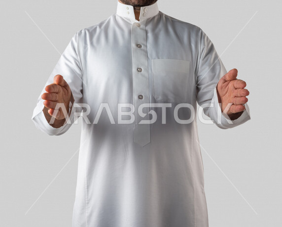 بورتريه لرجل عربي خليجي سعودي بايماءات يد مختلفة، يحمل شيء بين يديه، رفع وحمل شيء ما، اشارة الامساك، خلفية بيضاء