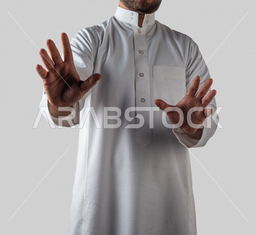 بورتريه لرجل خليجي سعودي يقوم بايماءات يد مختلفة ، ايماءة تدل عن الابتعاد والخوف من شيء، خلفية بيضاء