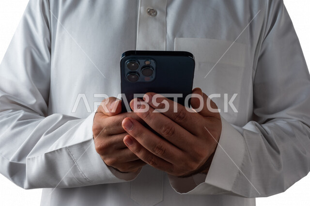 بورتريه لرجل خليجي سعودي يحمل بيده الهاتف المحمول ، اجراء اتصال فيديو ،تصوير سيلفي ،استخدام اجهزة تقنية حديثة ،  خلفية بيضاء