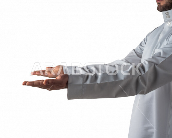 بورتريه لرجل خليجي سعودي يقوم بايماءات يد مختلفة، يفتح يديه لعرض شيء ما، يحمل شيء بين يديه، رفع و حمل شيء ما، اشاره الامساك، خلفية بيضاء