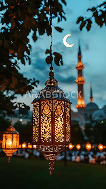 أجواء الاحتفال بالمناسبات والأعياد الدينية الاسلامية، ديكورات وزينة رمضان المبارك, الفوانيس المعدنية التقليدية المضاءة المعلقة في سماء المملكة العربية السعودية, منظر الهلال المضيء في السماء، البهجة بقدوم شهر الخير