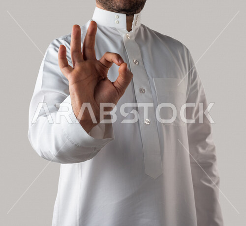 Hand portrait of a Saudi Gulf man making different hand gestures, a gesture indicating quality, workmanship, excellence and distinction, white background