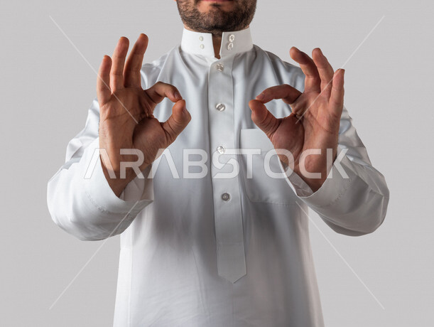 بورتريه ليد رجل خليجي سعودي يقوم بايماءات يد مختلفة ، ايماءة تدل على الجودة والاتقان، الامتياز والتميز ، خلفية بيضاء