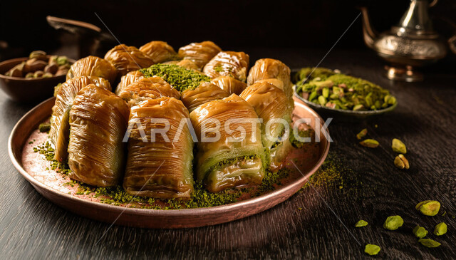 حلى سعودي بالفستق والمكسرات، طبق من الحلويات العربية الشرقية، مأكولات غنية بالسكريات والسعرات الحرارية، قطع البقلاوة الشهية، كرم الضيافة في المملكة العربية السعودية, منتجات محلية وطنية