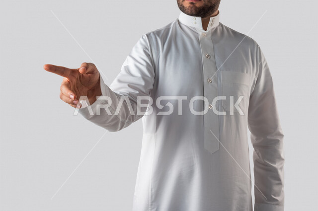 بورتريه لرجل خليجي سعودي يقوم بايماءات يد مختلفة، يشير باصبع السبابة باتجاه ما، النقر والضغط، حركة اصبع واشارات، خلفية بيضاء