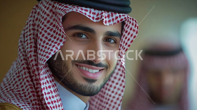  الاناقة والاهتمام بالمظهر الخارجي, صورة مقربة لرجل عربي خليجي سعودي مبتسم يرتدي الثوب التقليدي والشماغ ينظر الى الكاميرا بايماءات الثقة بالفس والسرور