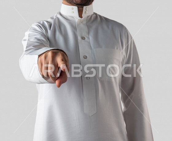 بورتريه لرجل خليجي سعودي يقوم بايماءات يد مختلفة، يشير باصبع السبابة باتجاه ما، النقر والضغط، حركة اصبع واشارات، خلفية بيضاء