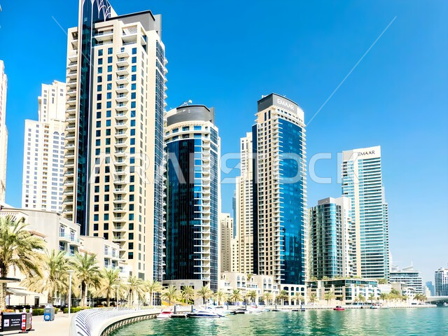 The growth and progress of modern architectural buildings and skyscrapers, luxury hotels and resorts overlooking the yacht marina in Dubai Marina on the coast of the Arabian Gulf, famous landmarks and tourist places in the United Arab Emirates