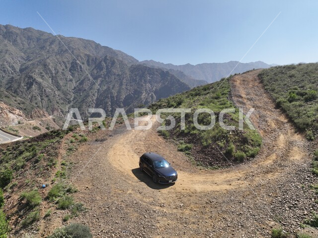 التشكيلات والتكوينات الصخرية في مدينة جازان، الأشجار والنباتات الخضراء المزروعة على جبال القهر, المناظر الطبيعية في الأماكن السياحية في المملكة العربية السعودية، سيارة تسير على طريق جبلي وسط السلاسل والمرتفعات