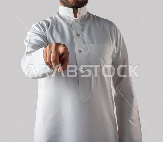 بورتريه لرجل خليجي سعودي يقوم بايماءات يد مختلفة، يشير باصبع السبابة باتجاه ما، النقر والضغط، حركة اصبع واشارات، خلفية بيضاء