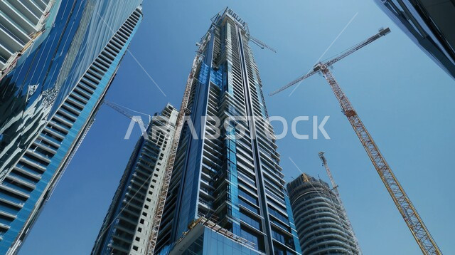 اعمال البناء وصب الخرسانات ووضع الأساسات، موقع بناء مزدحم بالآلات والمعدات الثقيلة والرافعات والسقالات العالية, مبنى قيد الانشاء في المملكة العربية السعودية, مفهوم الهندسة الانشائية والمعمارية، تنفيذ مخطط الإعمار وتشكيل الهيكل المعدني